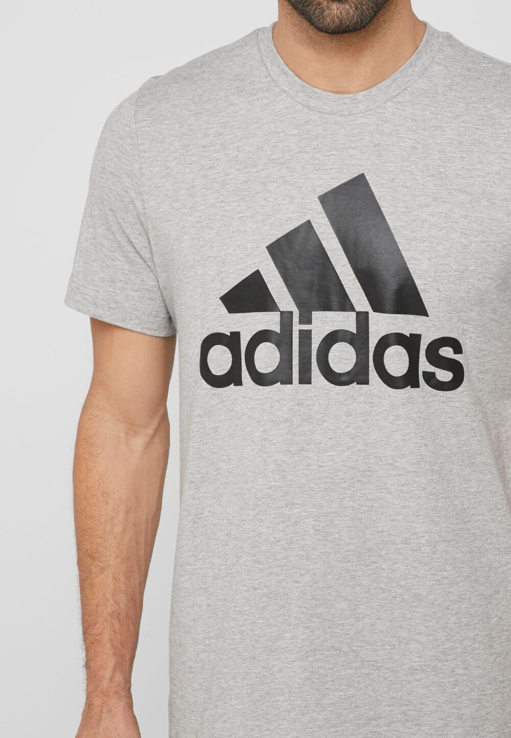 Adidas Essentials grey t-shirt with bold black logo, designed for comfort and style