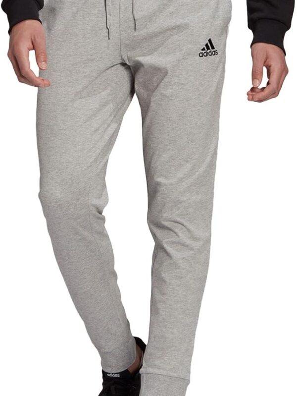 Adidas light gray men’s jogger pants with a slim fit, tapered legs, and black Adidas logo.