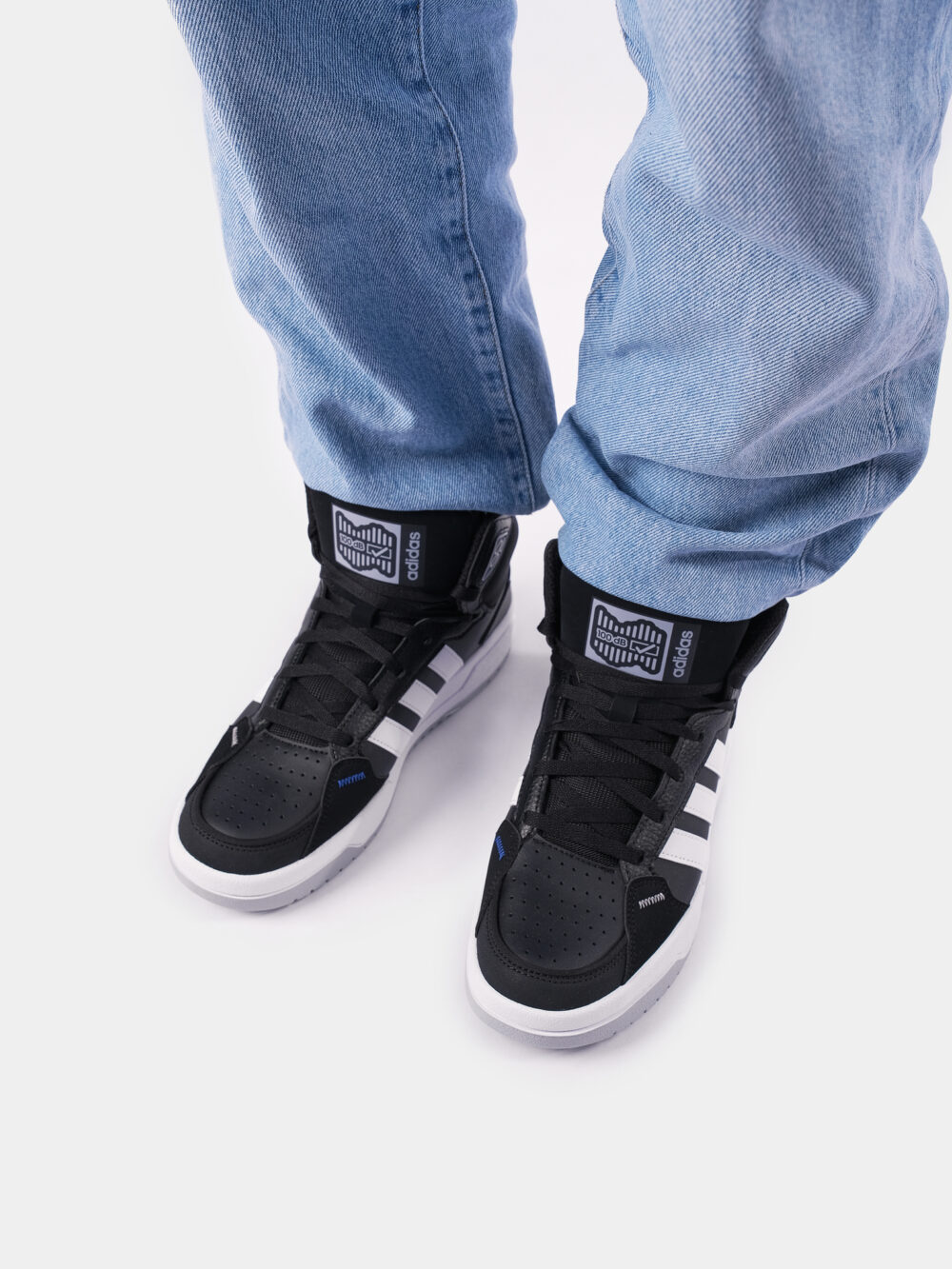 Adidas black and white high-top sneakers with three white stripes, blue accents, and a cushioned sole, perfect for casual streetwear or athletic use.