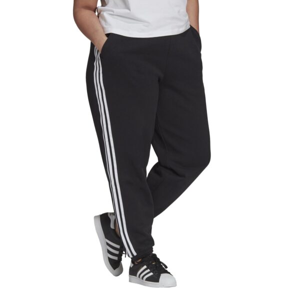 Adidas black plus-size track pants with white 3-stripes and the Adidas Trefoil logo, worn with Adidas Superstar sneakers.