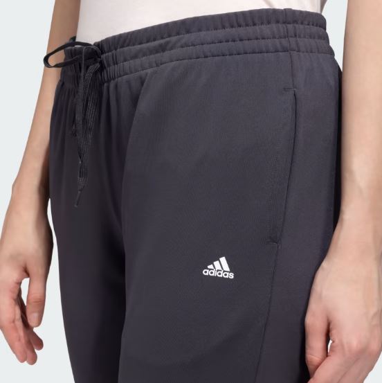 Adidas Women’s Jogger Pants in black with a tapered fit, adjustable drawstring waistband, and side pockets for casual comfort and style.