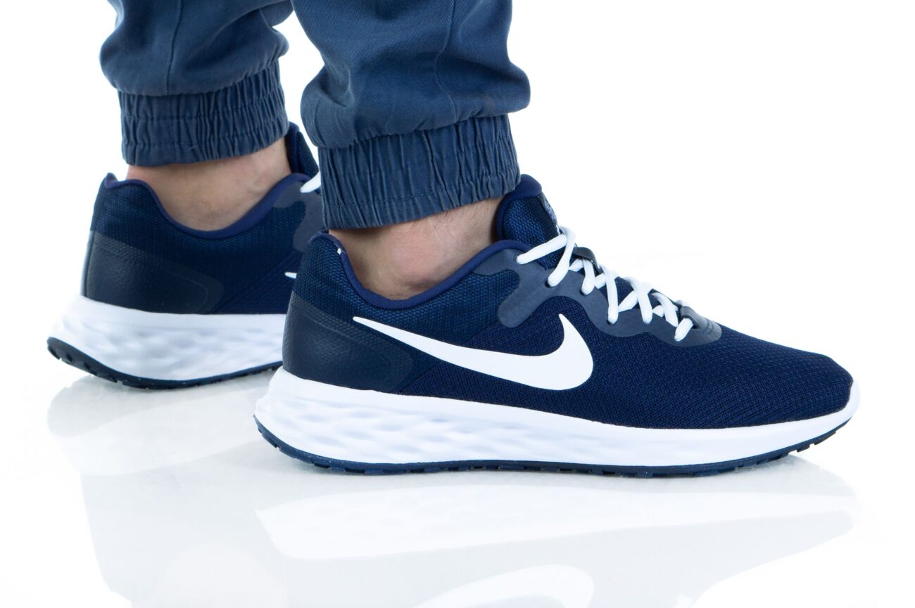 Close-up of Nike Revolution 6 NN men's running shoes in navy blue with white accents, featuring a breathable mesh upper and cushioned sole
