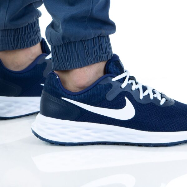 Close-up of Nike Revolution 6 NN men's running shoes in navy blue with white accents, featuring a breathable mesh upper and cushioned sole