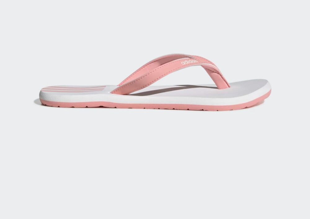 Adidas women's flip-flops in white with pink straps and iconic three-stripe branding, perfect for summer.