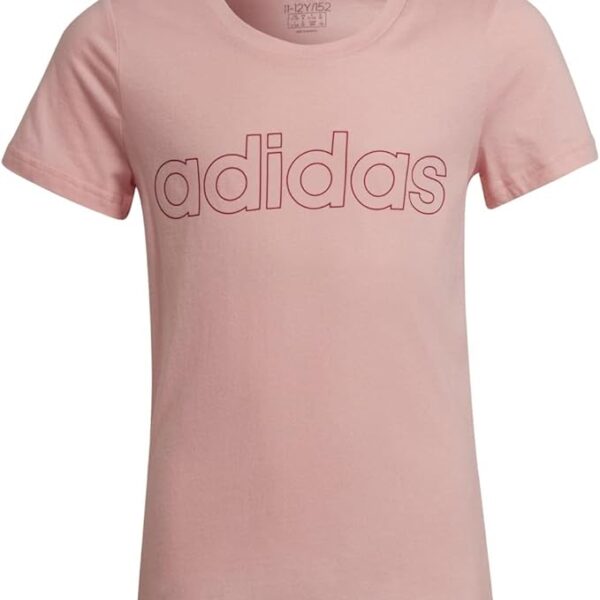 A young girl wearing a pink Adidas t-shirt with an embossed logo on the chest, paired with red pants, perfect for casual wear.