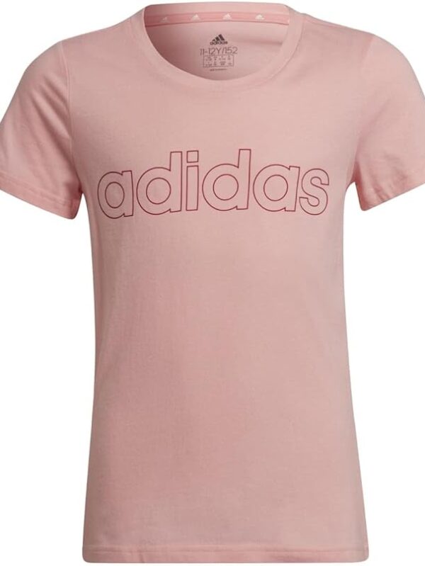 A young girl wearing a pink Adidas t-shirt with an embossed logo on the chest, paired with red pants, perfect for casual wear.