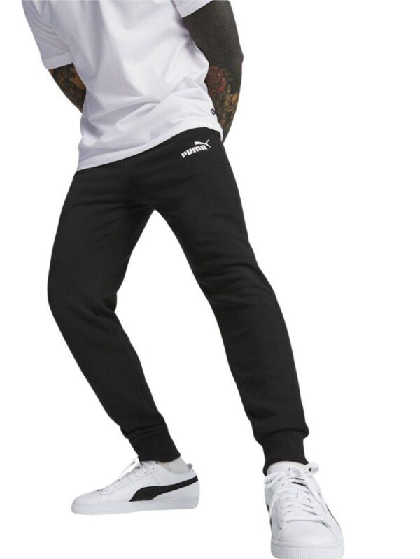 A man wearing Puma black slim-fit sweatpants paired with a white t-shirt and white sneakers, showcasing a casual and sporty look