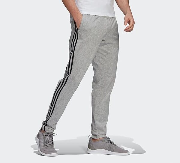 Adidas men's grey jogger pants with 3-stripe design, tapered fit, and side pockets.