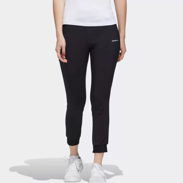 Adidas Essentials slim-fit joggers in black, designed for women with cuffed hems and a minimalist logo.
