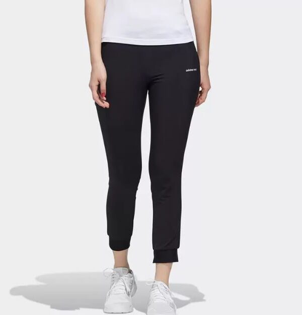 Adidas Essentials slim-fit joggers in black, designed for women with cuffed hems and a minimalist logo.