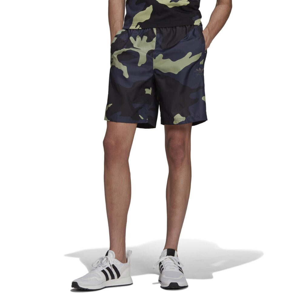 Adidas Men's Camo Print Shorts with an elastic waistband and side pockets, paired with white Adidas sneakers.