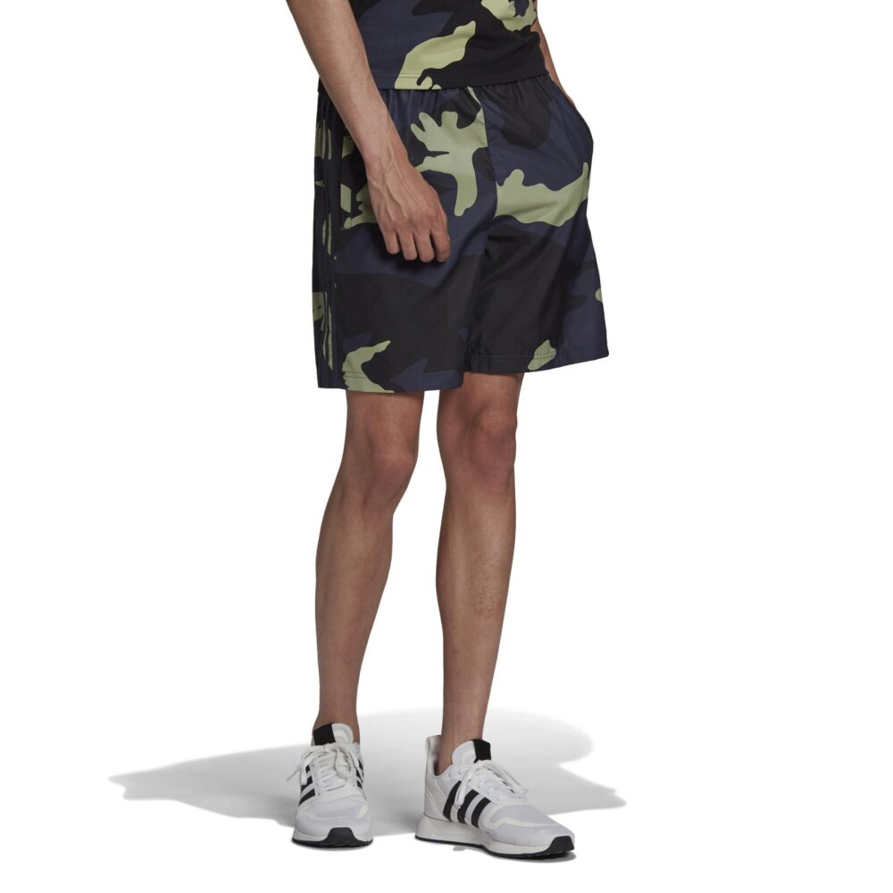 Adidas Men's Camo Print Shorts with an elastic waistband and side pockets, paired with white Adidas sneakers.