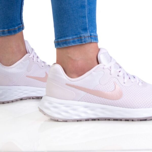 Nike women's light pink running shoes with cushioned sole and soft pink Swoosh logo.