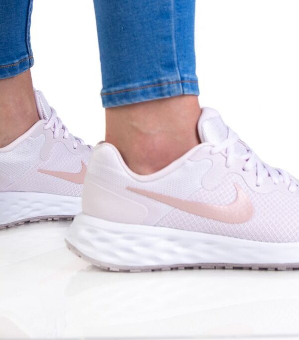 Nike women's light pink running shoes with cushioned sole and soft pink Swoosh logo.