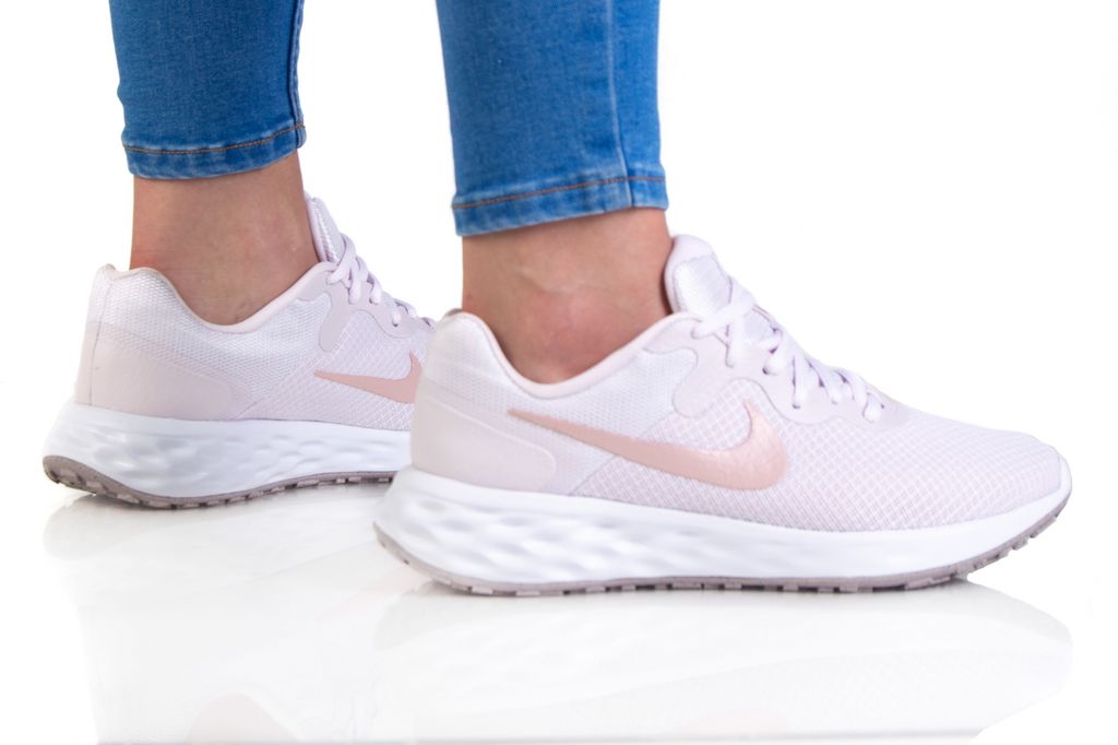 Nike women's light pink running shoes with cushioned sole and soft pink Swoosh logo.