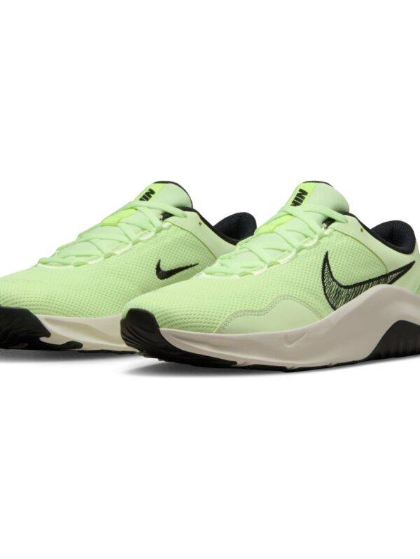 Nike women's light green running shoes with black Swoosh logo and cushioned sole.
