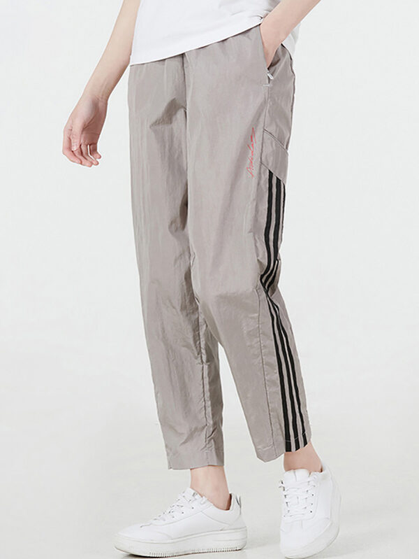Beige Adidas SST Track Pants with black 3-Stripes down the sides.