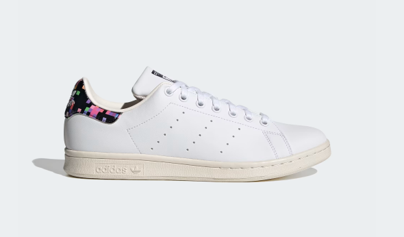 A pair of white Adidas Stan Smith Shoes with a colorful heel tab.