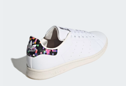 A pair of white Adidas Stan Smith Shoes with a colorful heel tab.