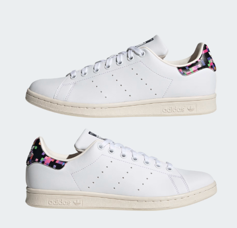 A pair of white Adidas Stan Smith Shoes with a colorful heel tab.