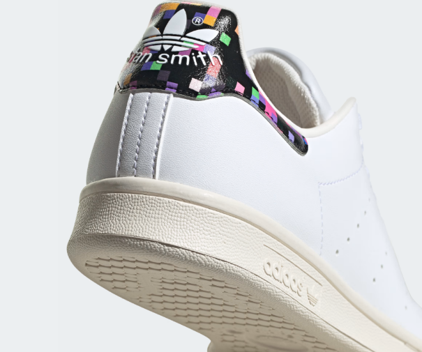 A pair of white Adidas Stan Smith Shoes with a colorful heel tab.