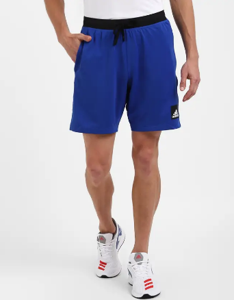 A person wearing solid blue Adidas City Functional Training Shorts.